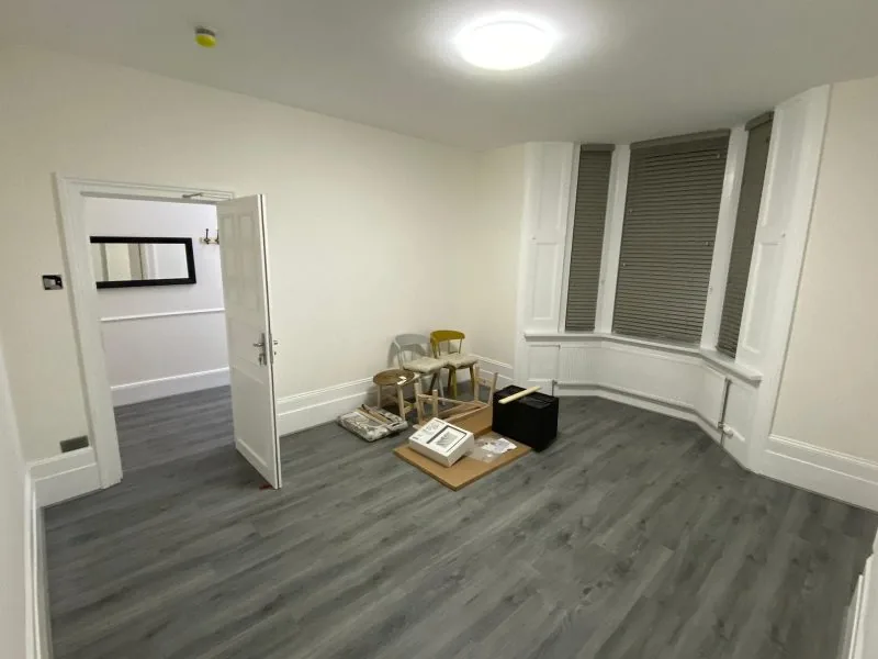Renovated room with grey wood-effect flooring and a bay window